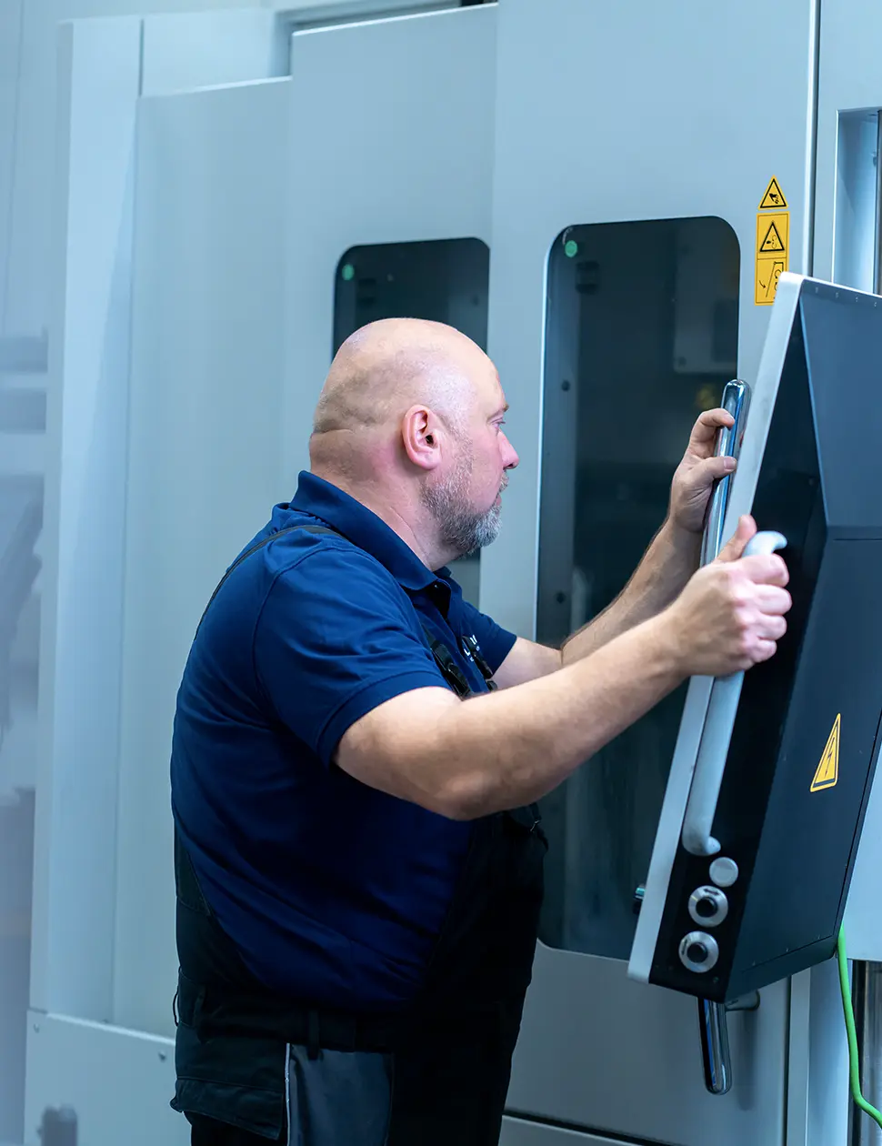 Mitarbeiter bedient eine Maschine