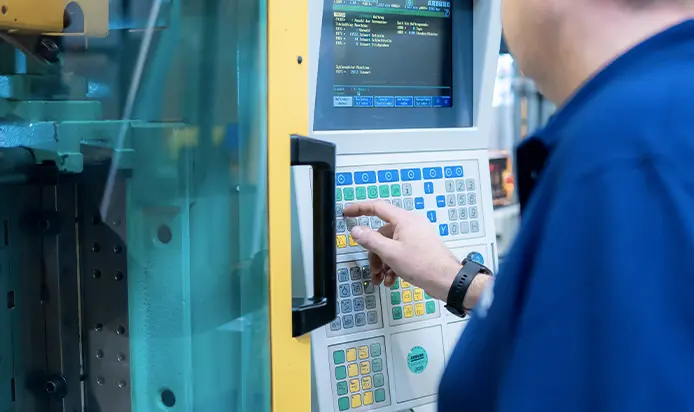 Mitarbeiter bedient eine Maschine